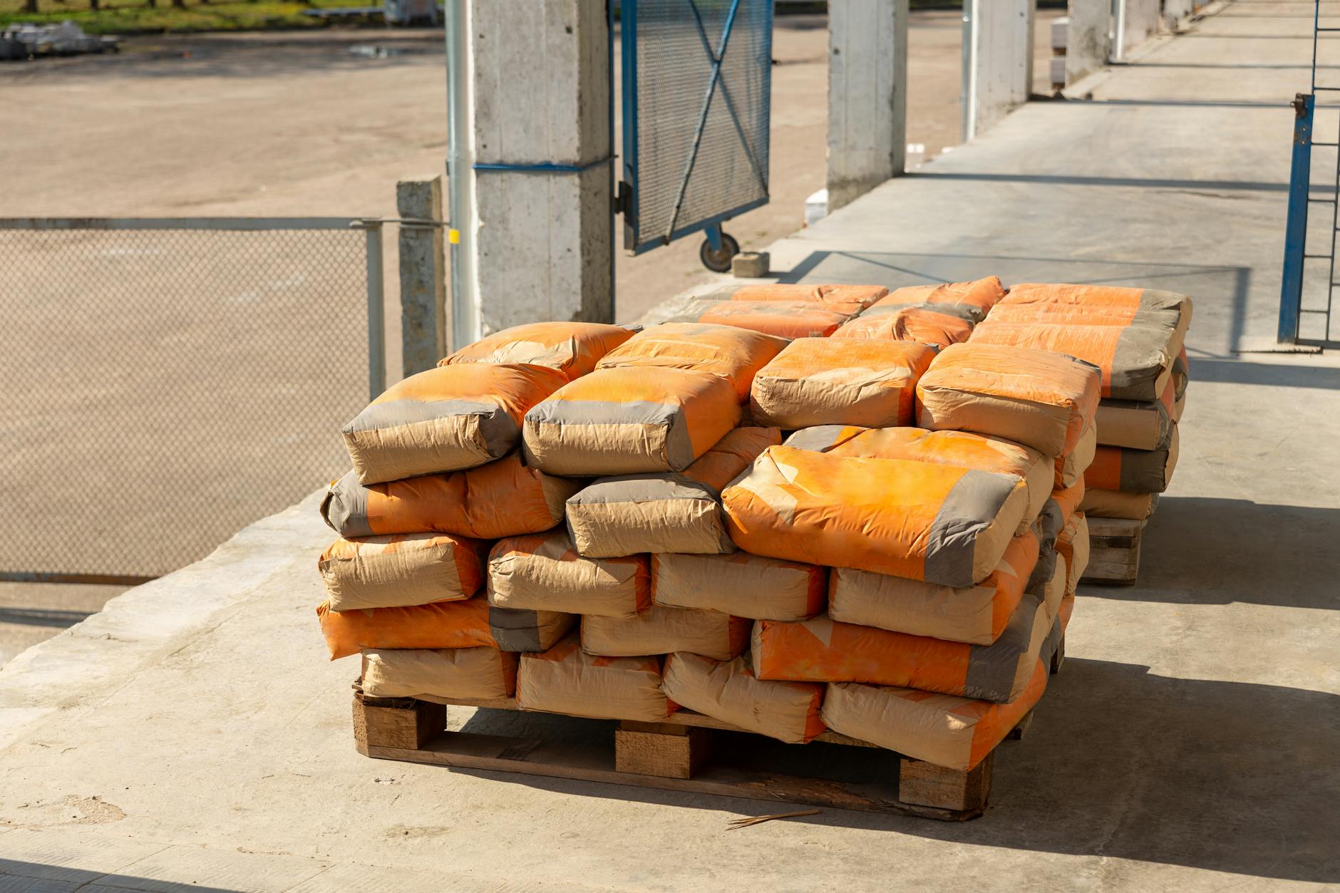 stacked cement bags on wooden pallet outdoors